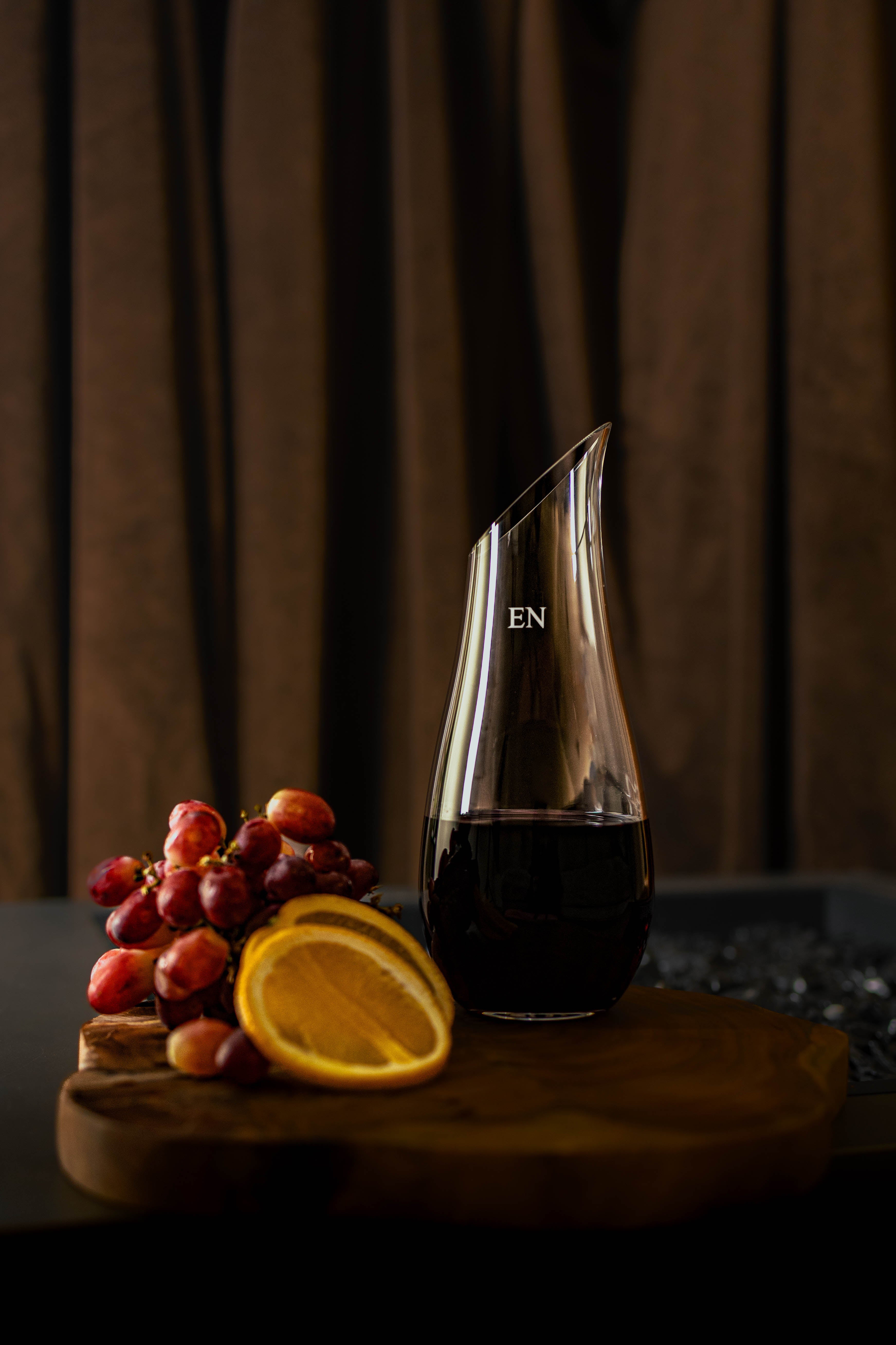 Wine or water carafe engraved with initials beside a serving of grapes