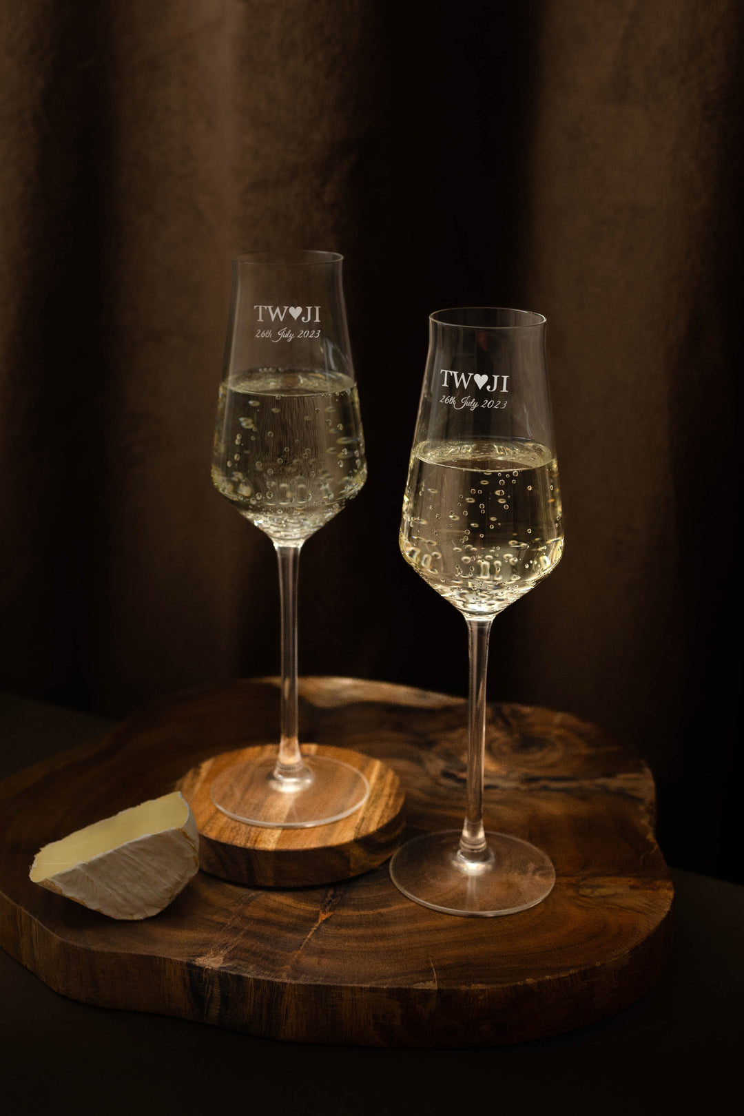 A pair of champagne flutes engraved with a couple's initials and their wedding date