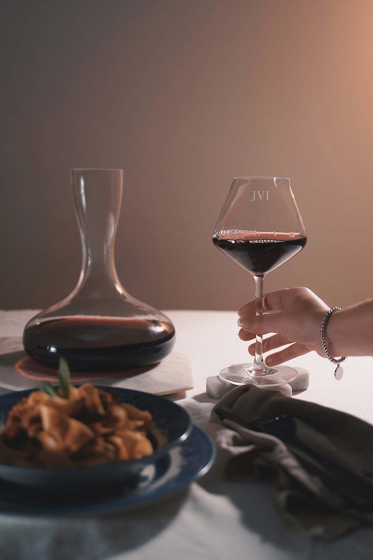 Engraved personalised red wine glass on a dinner table